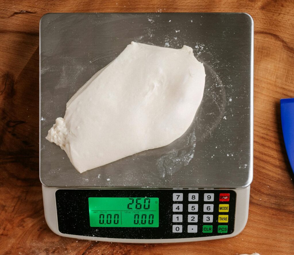Preparing dough on a kitchen scale for homemade baking projects.