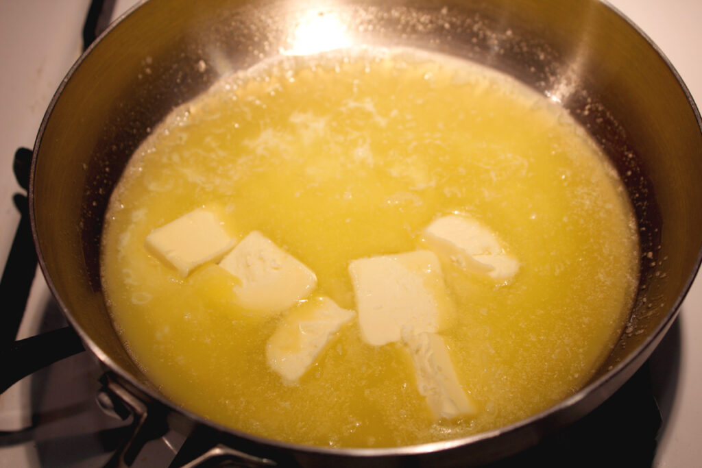 Butter beginning to melt in a pan on the stove