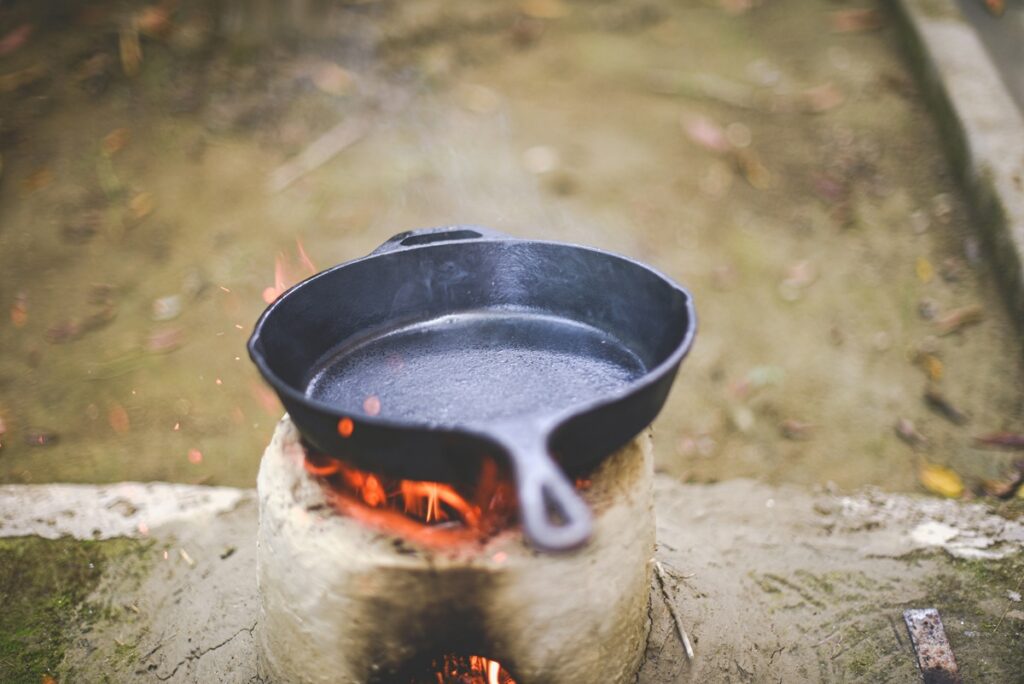 A cast iron pan over a fire outdoors