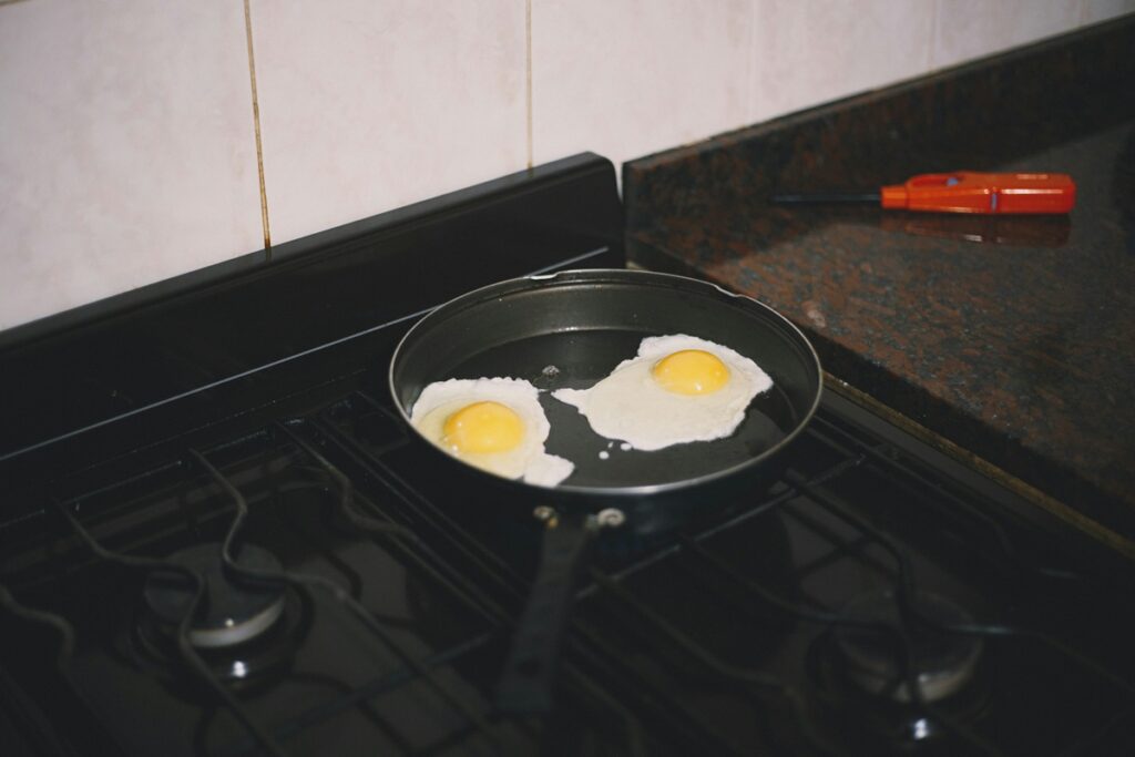 A Nonstick Pan with Eggs frying on a stovetop