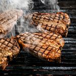 Perfectly grilled T-bone steaks sizzling on a BBQ grill using the to-zone grilling method